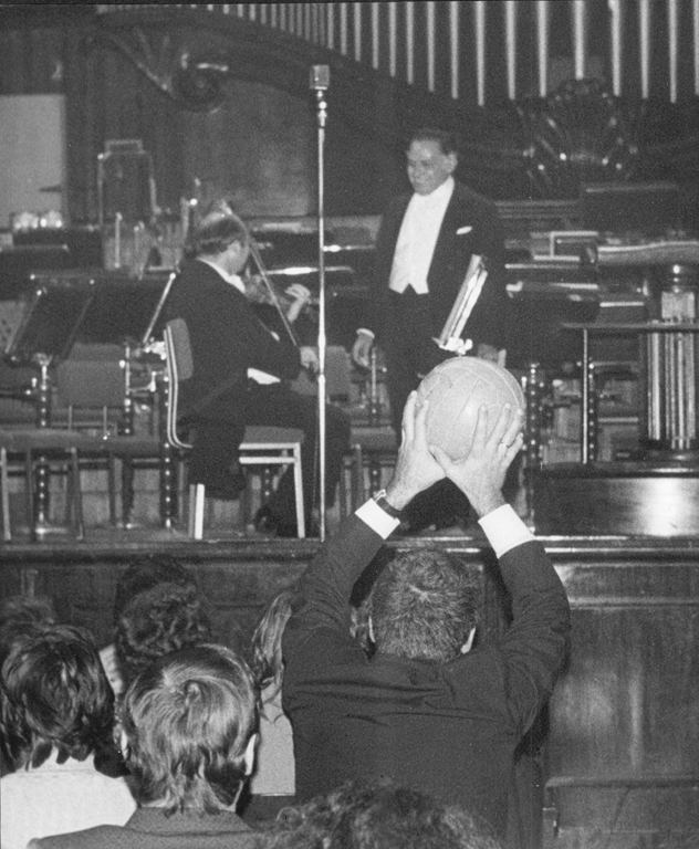 The conductor of Gilberto Mendes' Santos Football Music, Eleazar de Carvalho, has just thrown a ball to a member of the audience (24 September 1973), photo by CAF